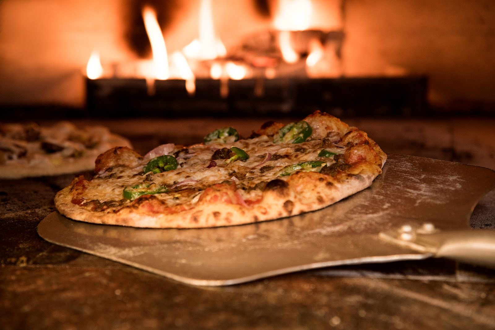 The red-tiled wood oven at Forno Rosso, flames at the back